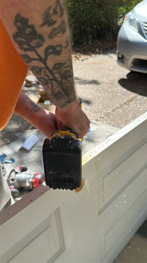 Trimming the bottom of a new interior door with a cordless saw in the driveway