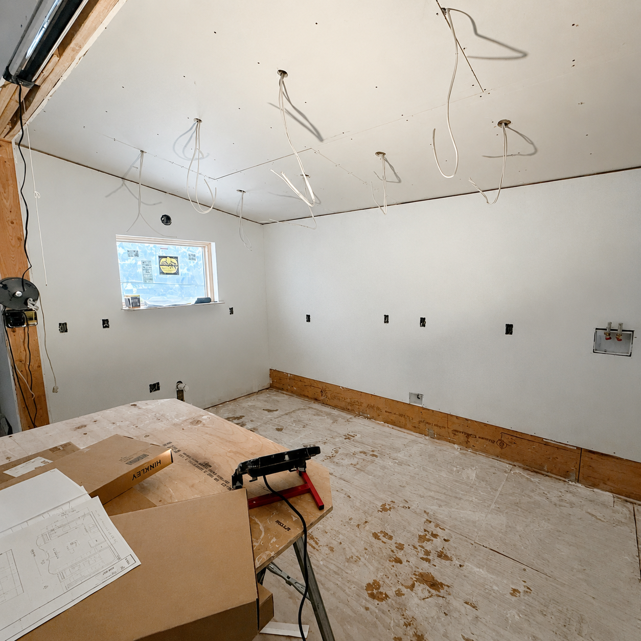 Newly drywalled room with ceiling light rough-in wiring and boxed fixtures waiting to be installed