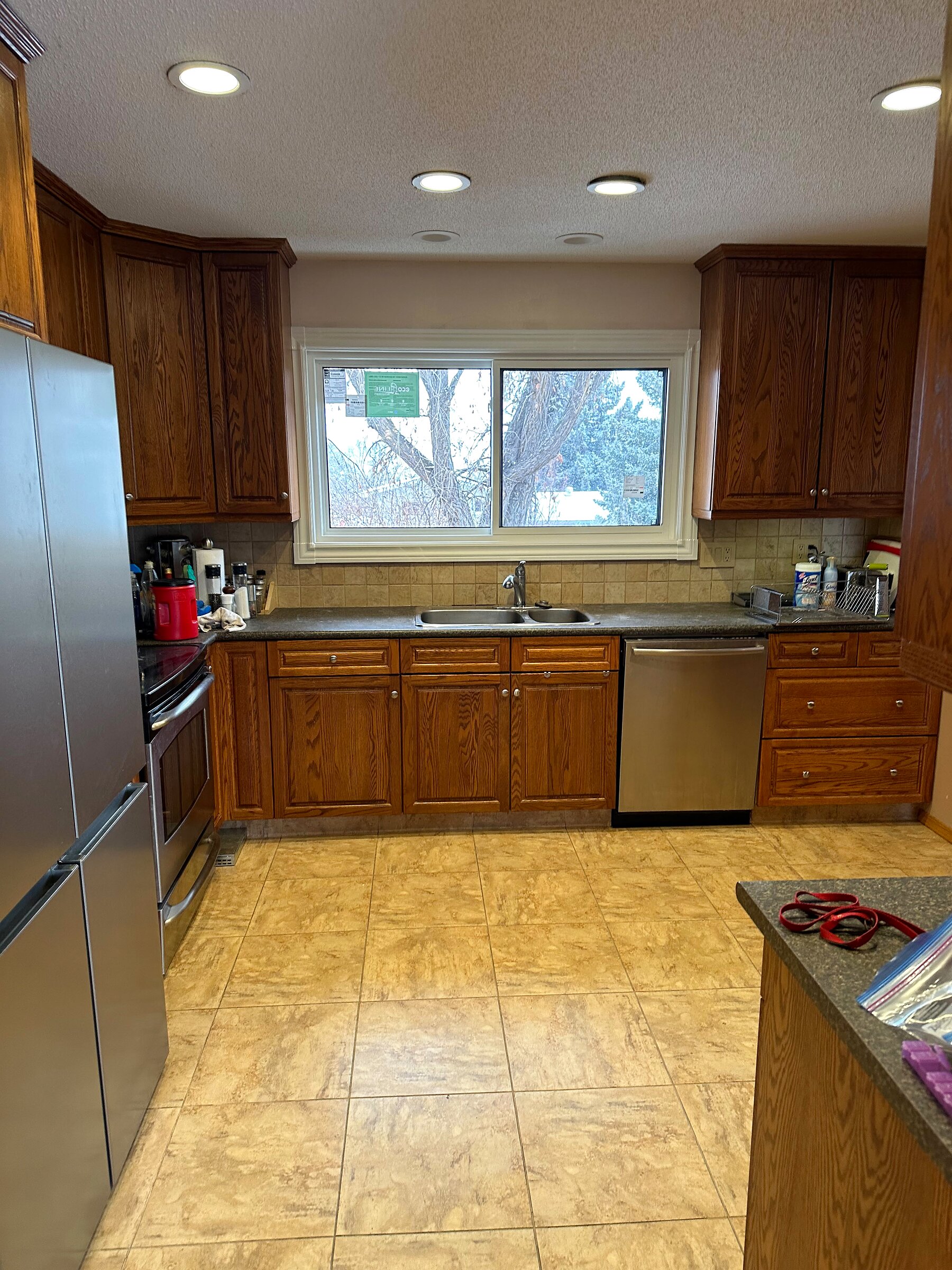 Rental unit kitchen with oak cabinetry, stainless appliances and tile flooring