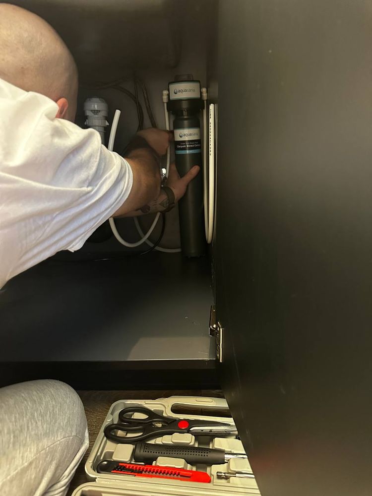Aquasana under-sink water filter mounted and connected inside a kitchen cabinet