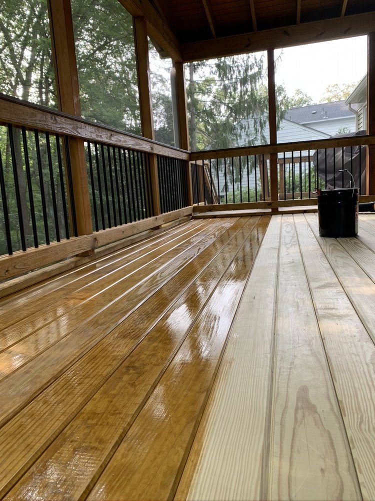 Covered deck half stained, showing the color difference between finished and bare boards