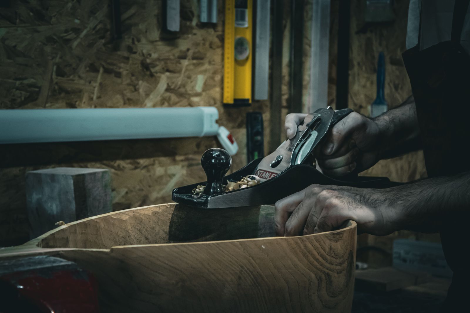 Craftsperson smoothing a board with a hand plane
