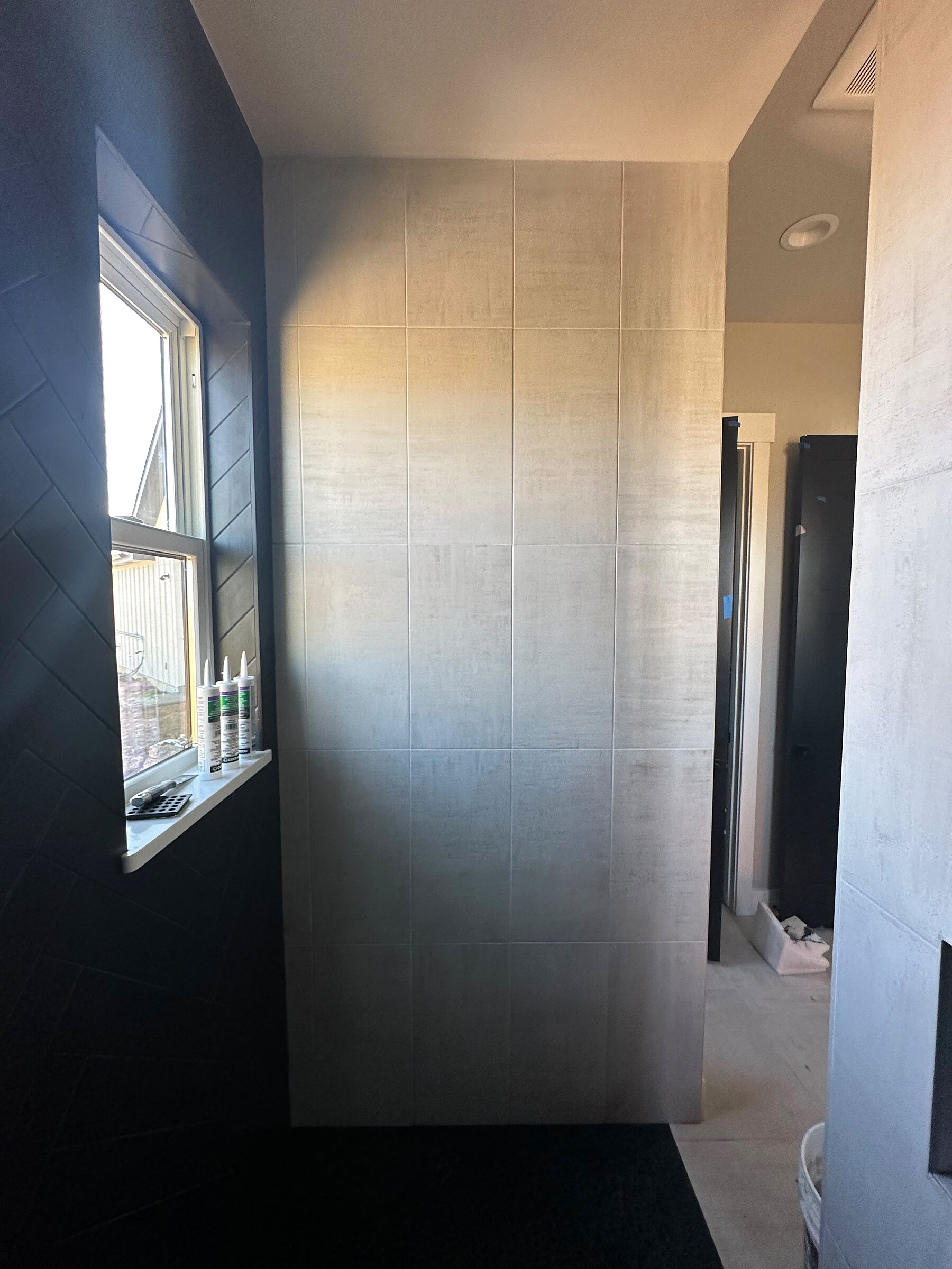 Shower wall mid-tile installation with a window opening, primary bathroom remodel