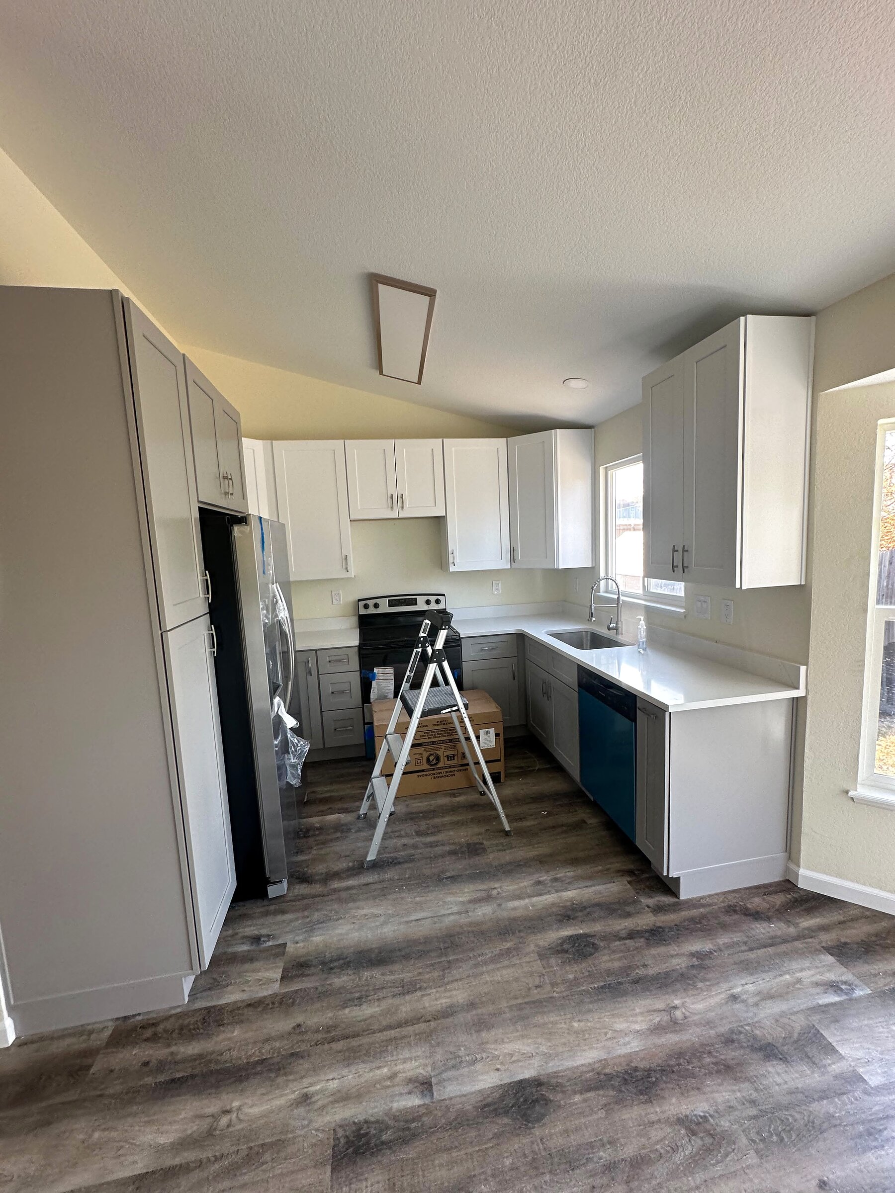 Remodeled kitchen with gray and white cabinetry, quartz counters and new stainless appliances