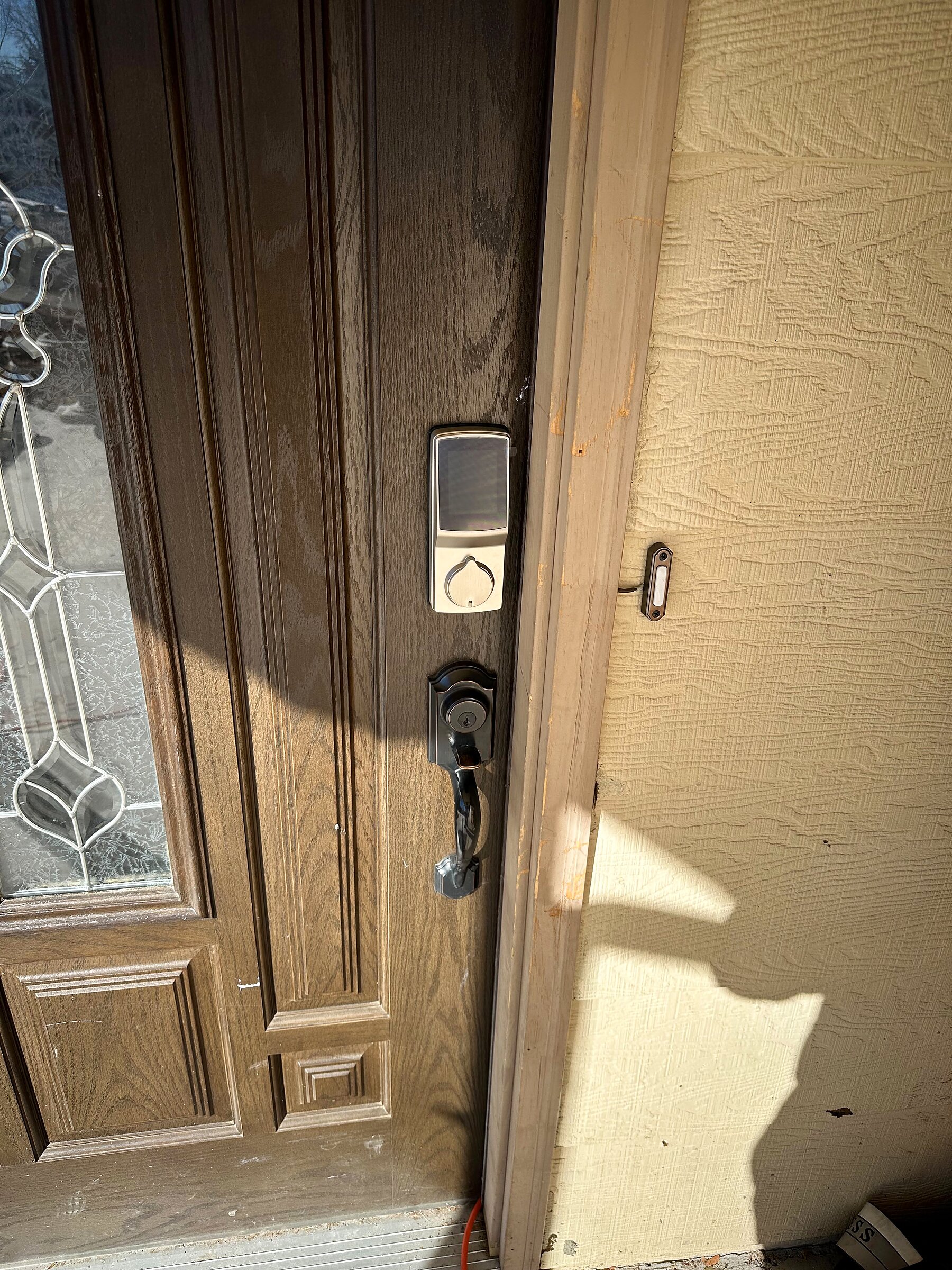 Exterior front door with new smart lock deadbolt being installed