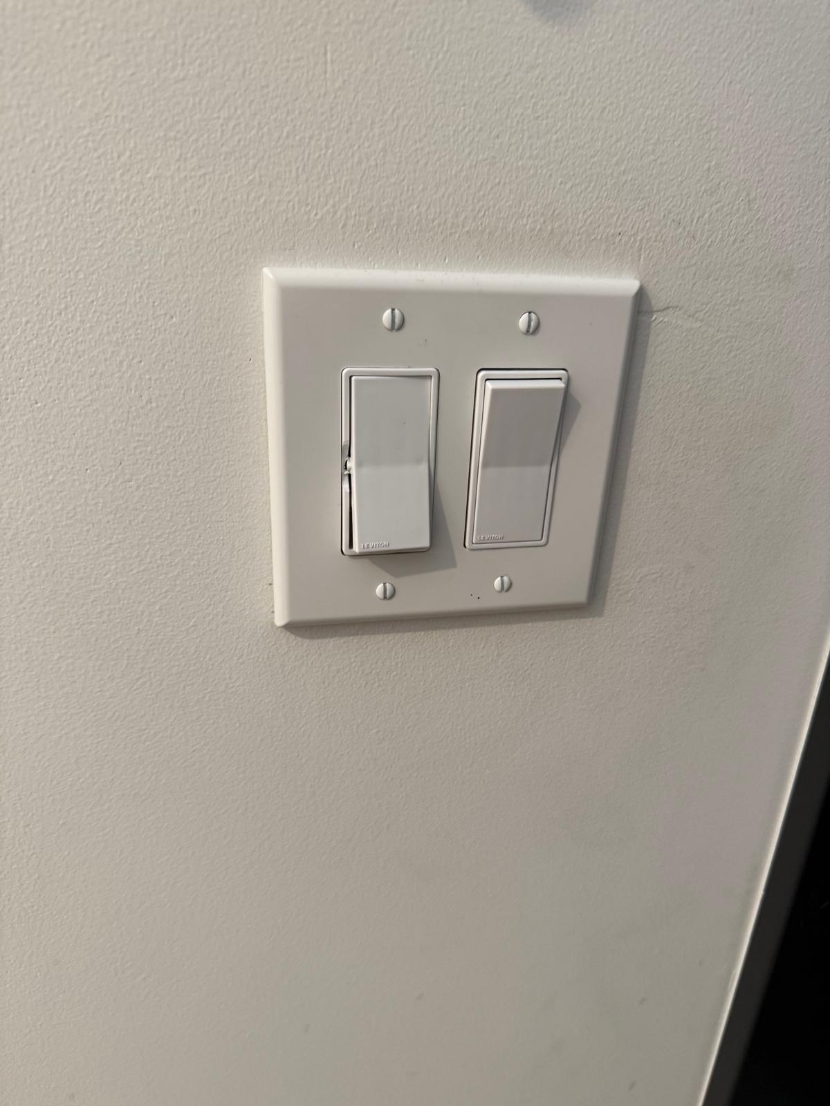 Newly installed two-gang Leviton rocker switch set with a clean white wall plate