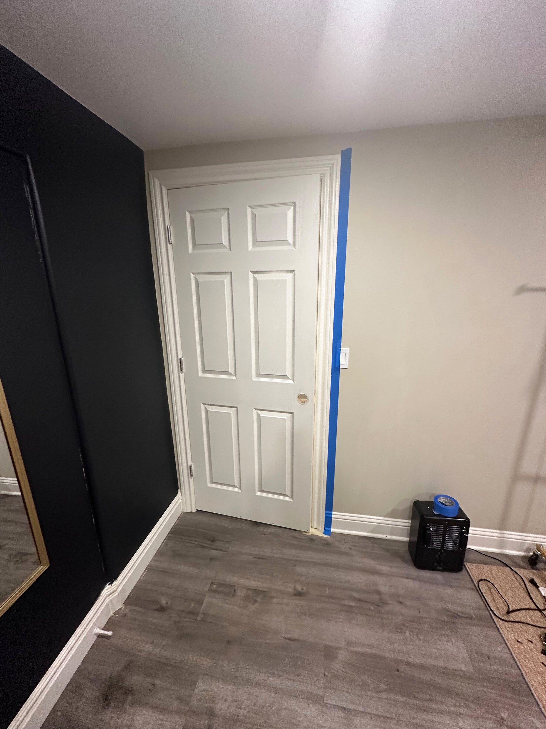 White interior door off its hinges with lockset hole prepped for new hardware