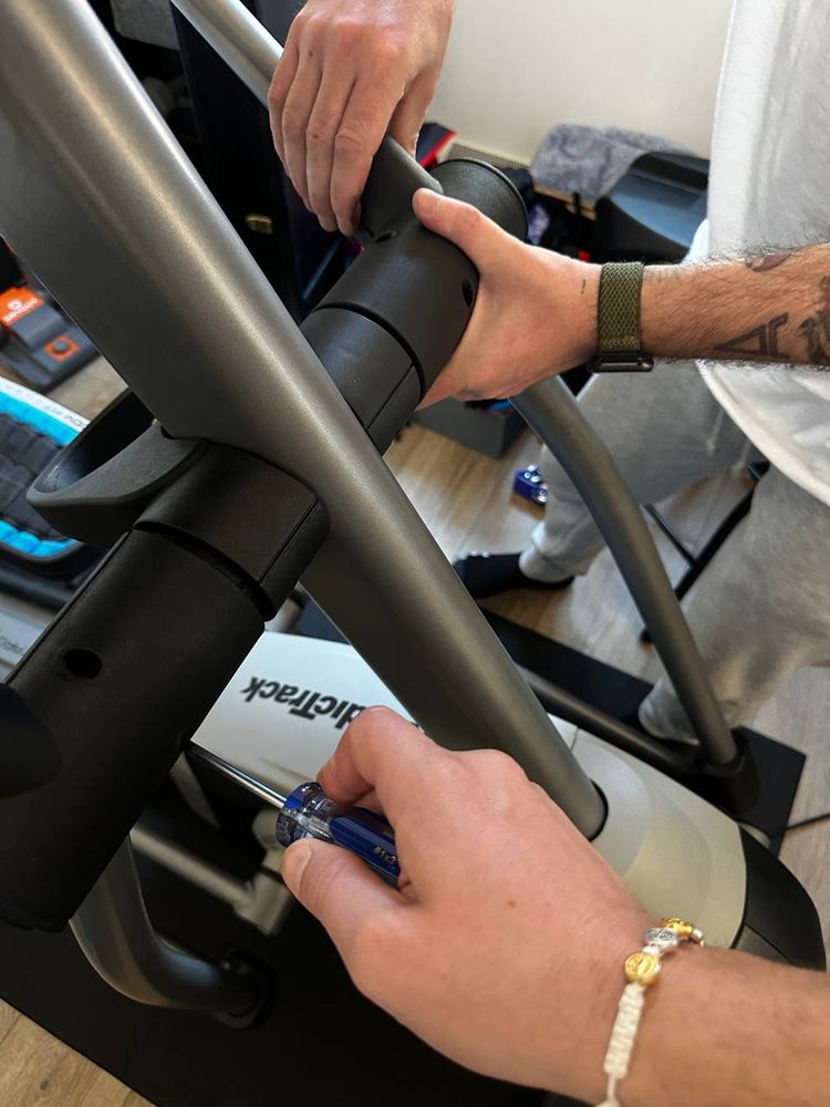 Bolting the upright arms onto a NordicTrack treadmill during in-home equipment assembly