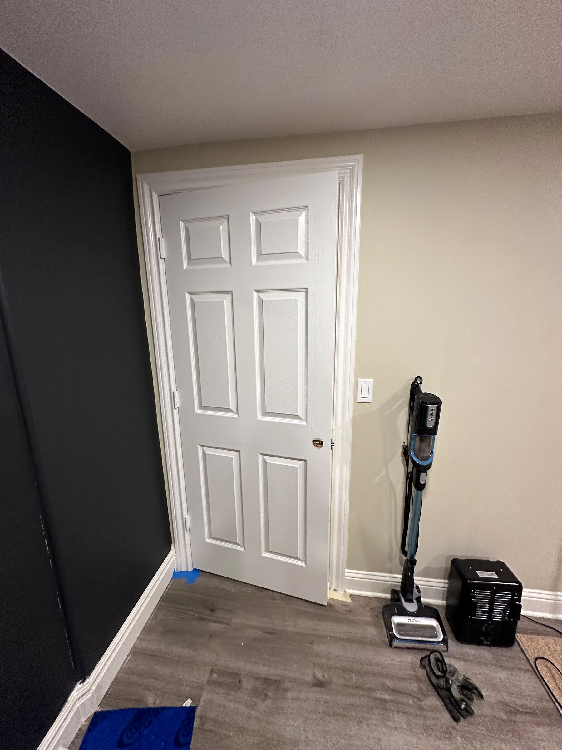 White panel door installed in a hallway with a door closer
