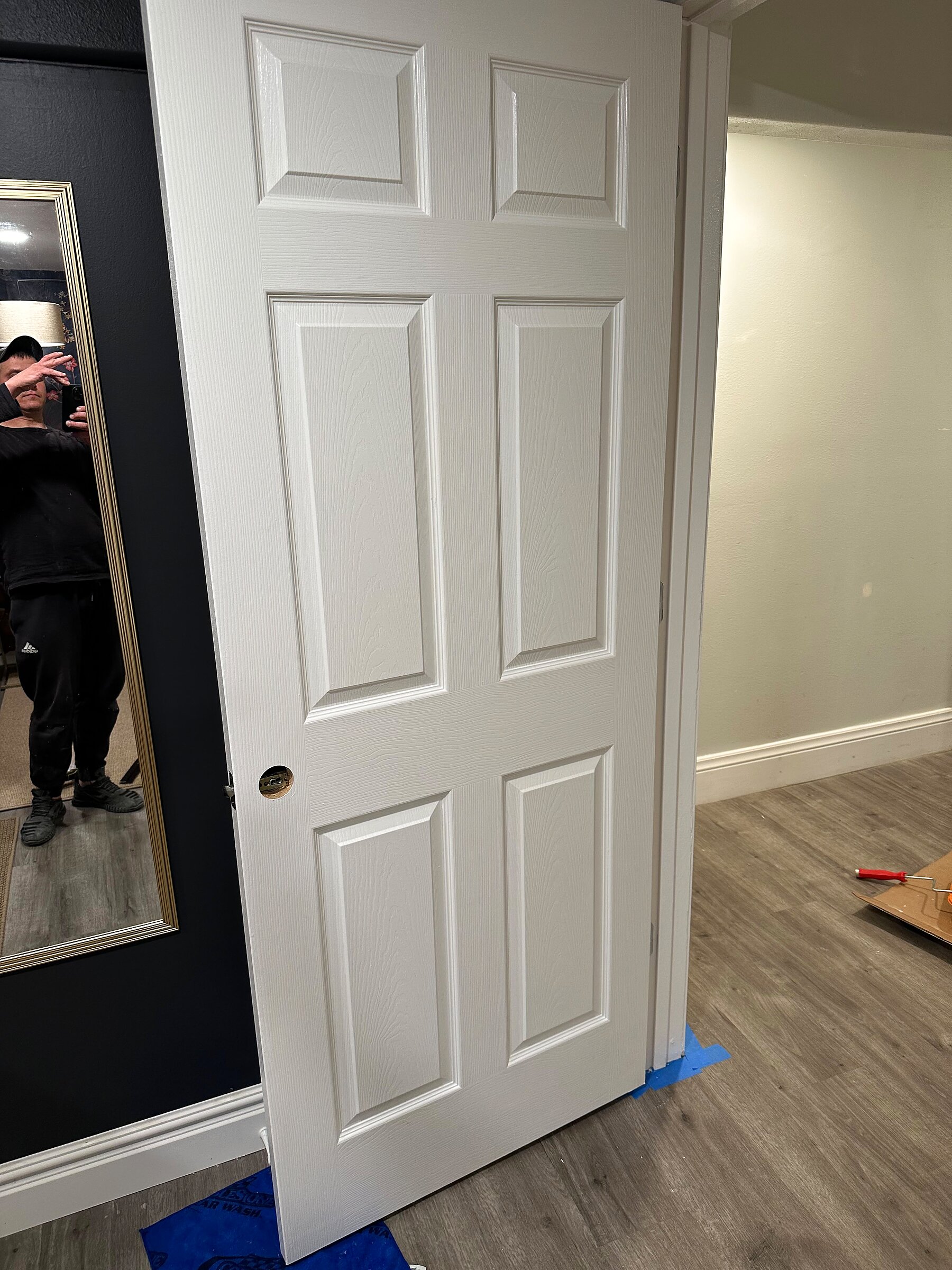 White interior door rehung in its frame with hardware prep underway