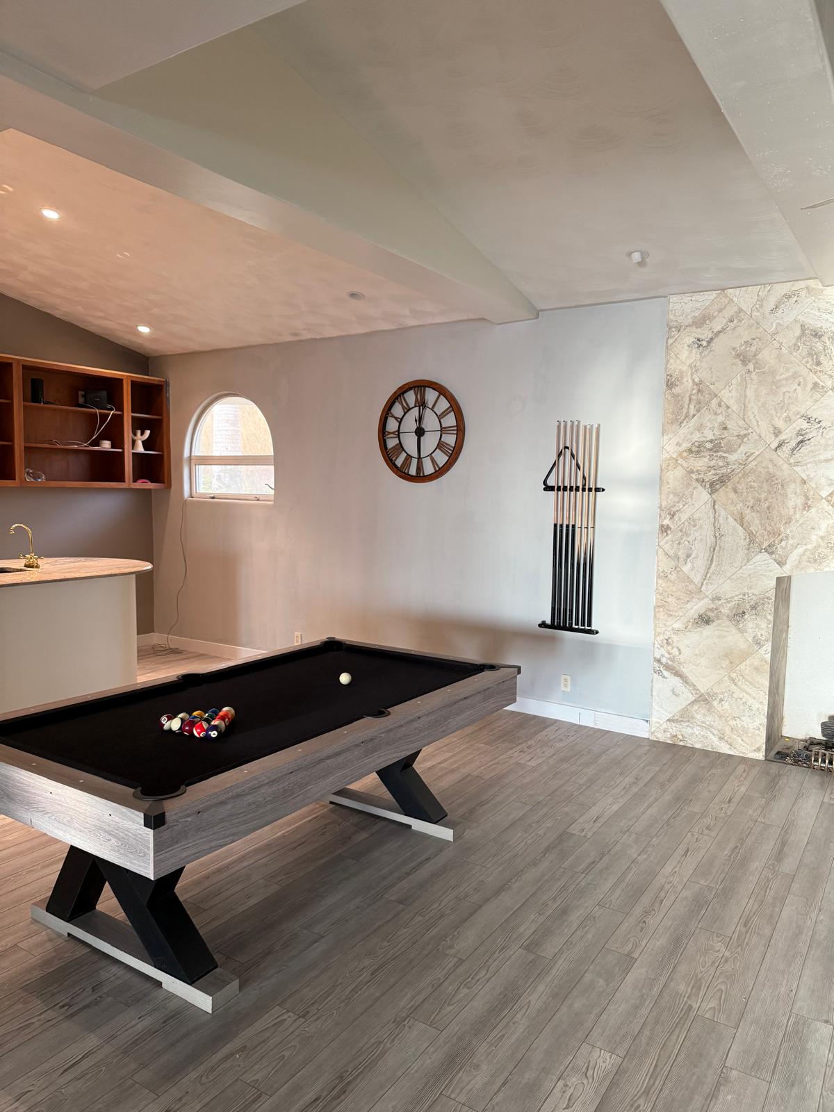 Finished game room after interior repaint with clean walls, vaulted ceiling and a pool table set up