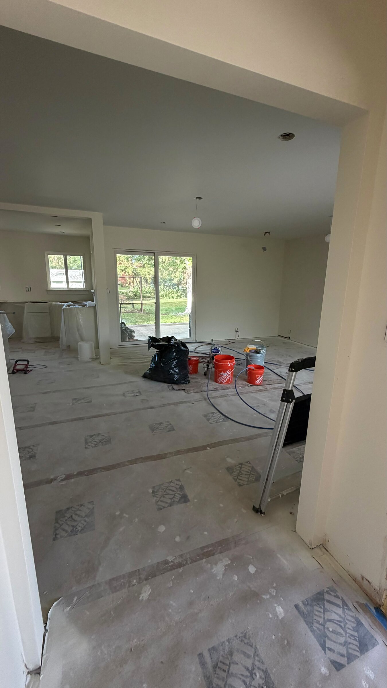 Open living area with subfloor prep, a sliding glass door leading to the backyard