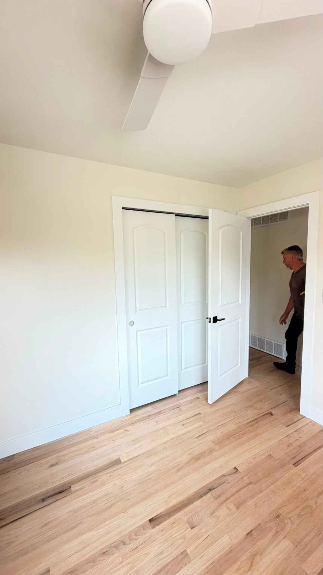 Finished bedroom closet doors with white paneled doors, casing and new hardwood flooring
