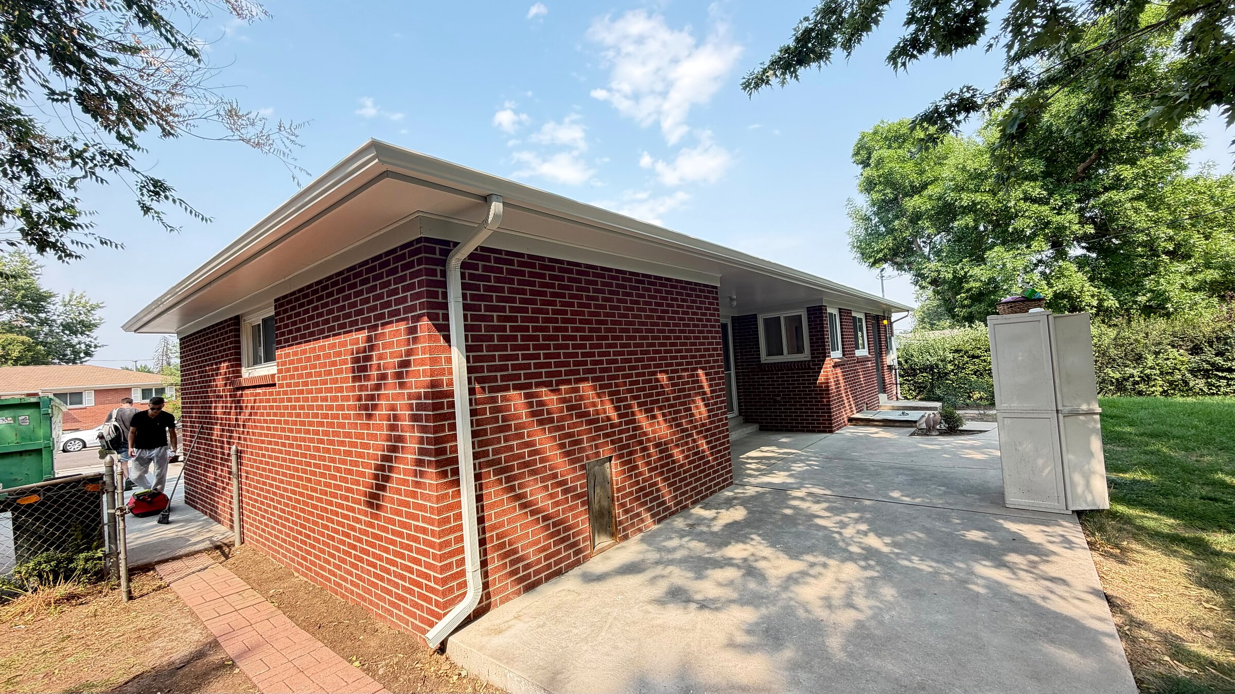 Side yard exterior of the finished brick home, patio and concrete walkway