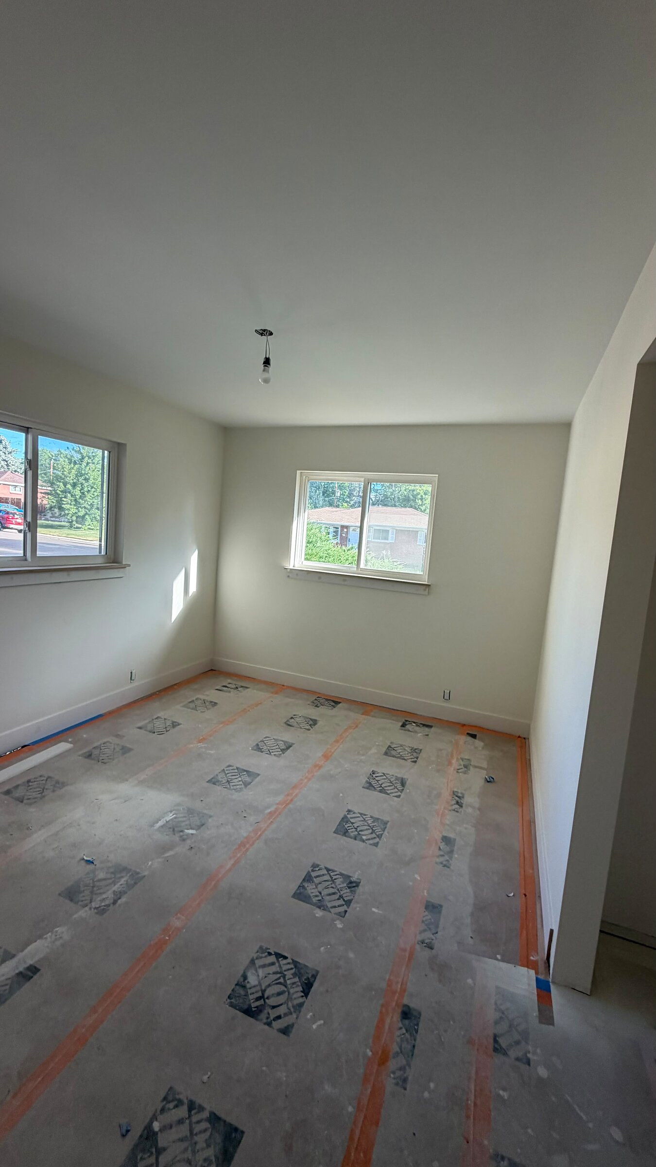Bedroom with subfloor prep underway ahead of new flooring, bright window light