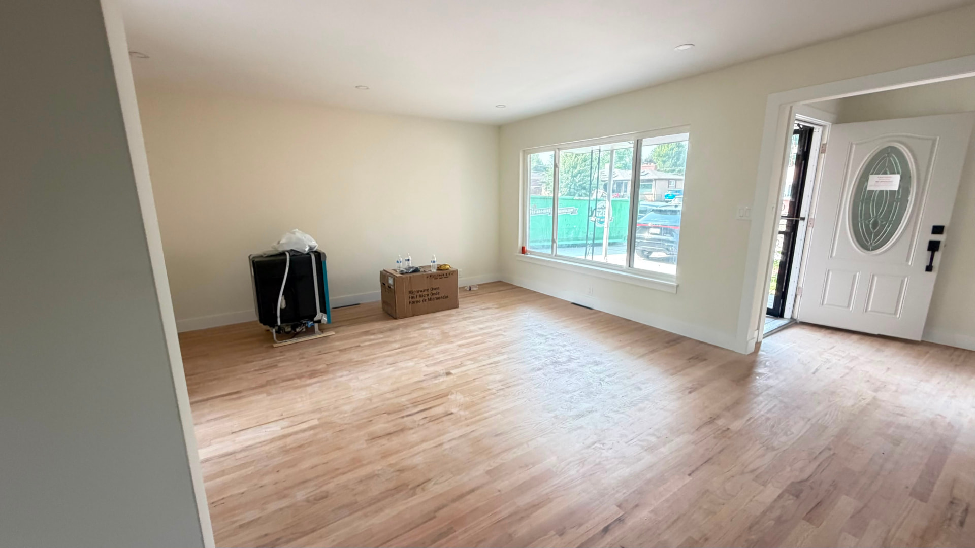 Completed living room with new hardwood flooring and finished white walls