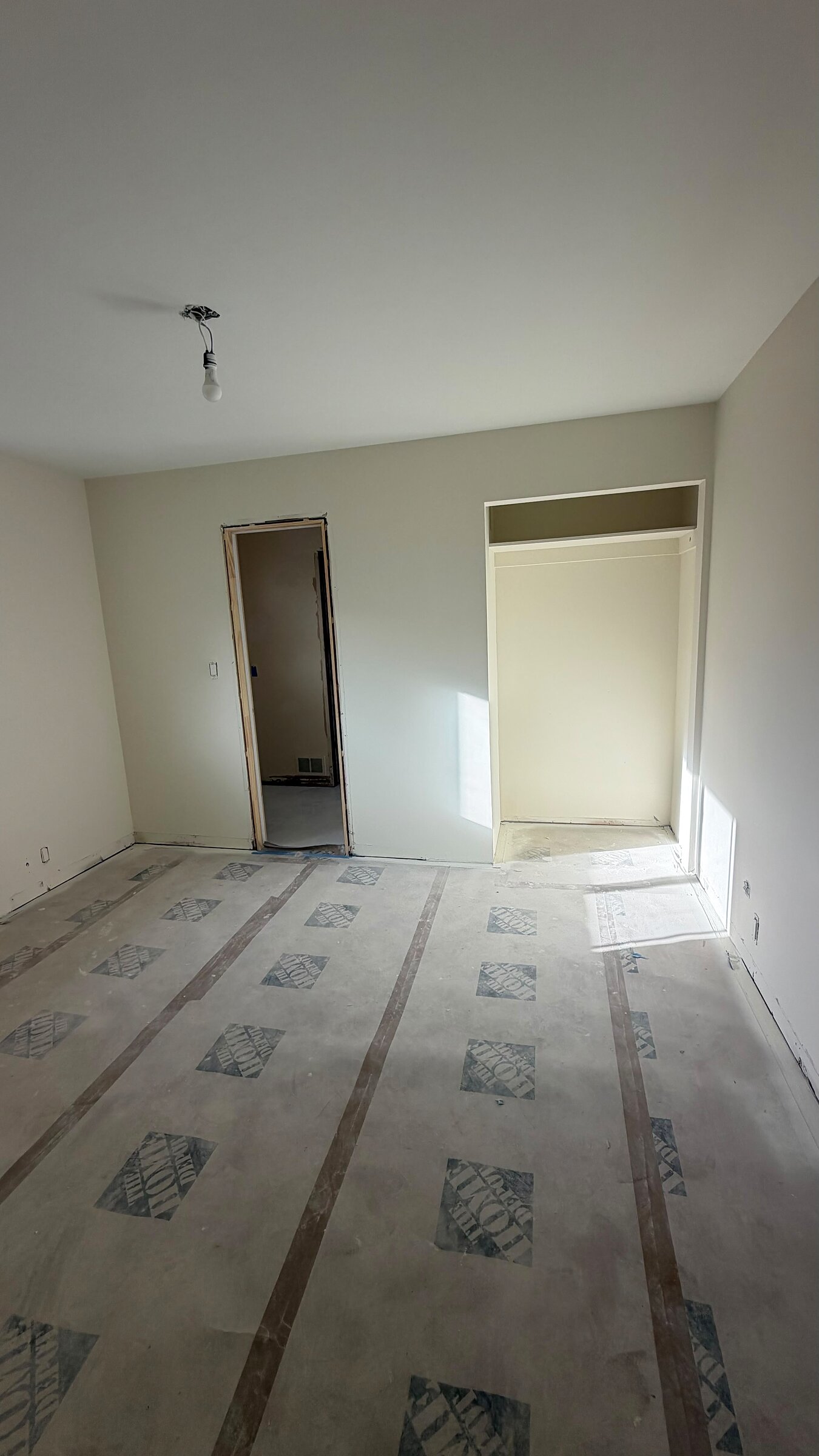 Bedroom with a newly framed doorway and closet, subfloor exposed ahead of flooring