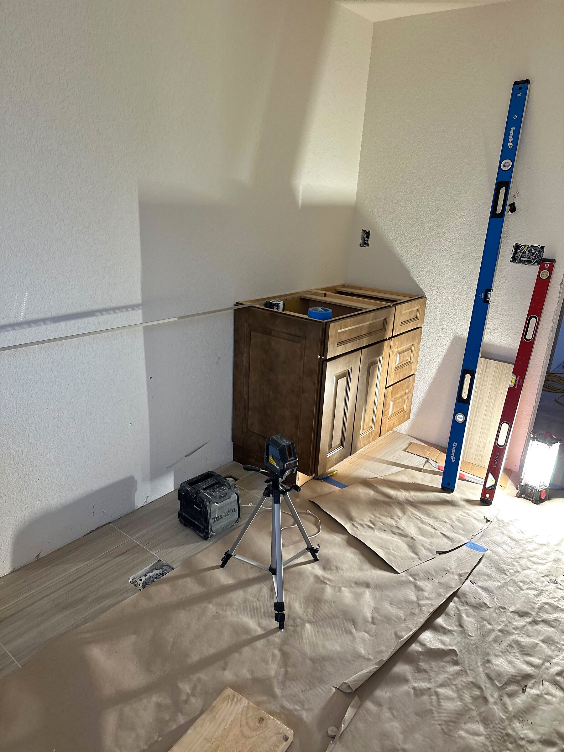 Corner vanity cabinet checked for level with a laser level tool